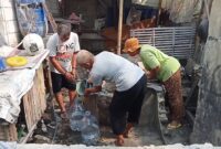 KEKERINGAN: Warga dadap mengambil air dari sumur keramat 
mengunakan galon.