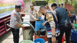 PEDULI: Anggota Polsek Panongan membantu pendistribusian air bersih untuk warga.