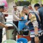 PEDULI: Anggota Polsek Panongan membantu pendistribusian air bersih untuk warga.