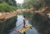 Warga Desa Renged, Kecamatan Kresek, Kabupaten Tangerang menggunakan rakit menyebrangi Sungai Cidurian, Senin (9/10/2023).