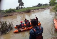 PENCARIAN KORBAN: Petugas BPBD Kabupaten Tangerang saat pencarian korban tenggelam di Sungai Cimanceuri.
