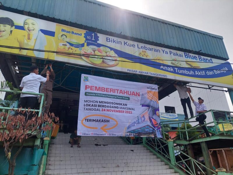 Petugas Satpol PP saat memasang spanduk pemberitahuan untuk pengosongan lokasi berdagang di Pasar Anyar.