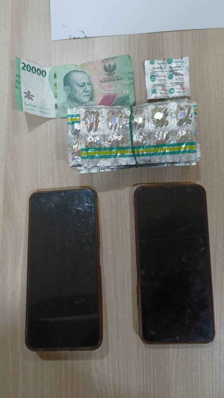 BARANG BUKTI: Obat, uang dan telepon yang diamankan polisi dari pelaku pengedar obat keras tanpa izin.