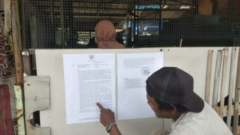 SURAT PEMBERITAHUAN: Pedagang Pasar Kutabumi, Kabupaten Tangerang saat melihat surat pemberitahuan pembongkaran Pasar Kutabumi.
