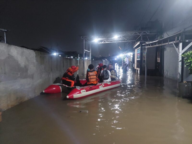 EVAKUASI: Petugas BPPBD Tangerang Selatan mengevakuasi salah satu warga akibat permukiman yang tergenang dilanda banjir.