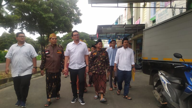 DIKAWAL BANSER: Erlangga Yuda (tengah) mengembalikan formulir ke DPC PKB Kota Tangerang, di Komplek Taman Royal I, dikawal Banser, kemarin.