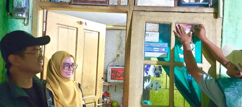 TEMPEL: Petugas PPDP saat menempelkan bukti warga sudah dicoklit, disaksikan Kodiv Pencegahan, Partisipasi Masyarakat, dan Humas Bawaslu Kabupaten Tangerang Ikbal Al Ambari, Selasa (25/06/2024).